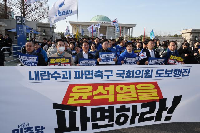 더불어민주당 의원들이 윤석열 대통령 파면 촉구 도보 행진에 참여한 지난 13일 서울 여의도 국회에서 광화문을 향해 출발하고 있다 사진연합뉴스