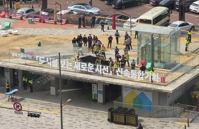 7일 낮 서울 중구 도시건축전시관 옥상에서 소방관들이 윤석열 대통령 지지자로 추정되는 한 남성의 분신 시도 현장을 수습하고 있다 사진연합뉴스