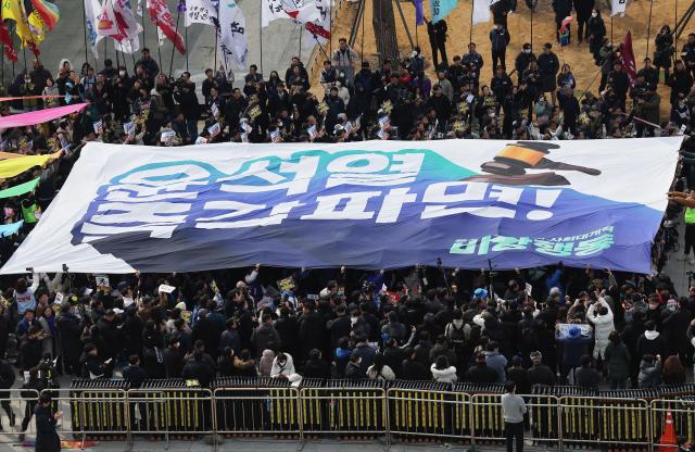 17일 서울 종로구 광화문광장에서 윤석열 즉각퇴진·사회대개혁비상행동 주최로 열린 윤석열 즉각 파면 촉구 각계 긴급시국선언 집회에서 현수막 퍼포먼스가 진행되고 있다 사진연합뉴스