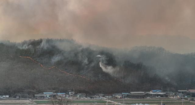 22일 경북 의성군 의성읍 원당2리 마을 인근까지 산불이 번진 가운데 산불진화헬기가 산불 진화에 나서고 있다 사진연합뉴스