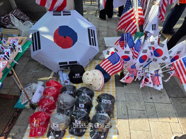 4일 서울 용산구 한남대로 일대에서 열린 탄핵 반대 집회에서 태극기를 비롯한 여러 물품을 판매하고 있다. [사진=이지환 기자]
