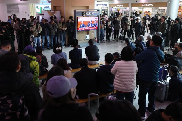  4일 서울역 대합실에서 이용객들이 윤석열 전 대통령 탄핵심판 선고 생중계를 보고 있다 