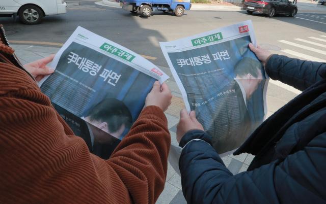 4日,首尔中区地铁市厅站出口,市民们在阅读韩国前总统尹锡悦罢免宣判号外报纸。【图片提供 亚洲经济】