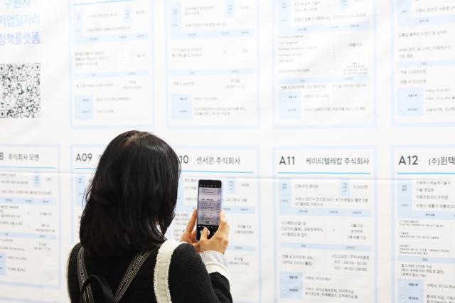 9日,在京畿道水原市举行的“水原工作岗位博览会”上。青年们在查看招聘公告栏。【图片新闻 韩联社】