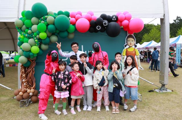 김철우 군수와 어린이들이 함께 오징어게임 포토존에서 사진 촬영을 하고 있다 사진보성군