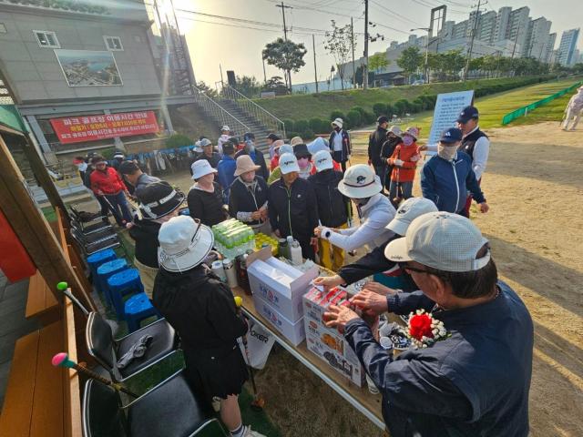 파크골프장에서 떡 등 다과를 나눠주는 모습 사진김규남 기자