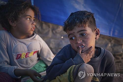 2025년 5월 9일 가자지구 남부 칸유니스의 한 급식소에서 식재료가 바닥나 엄마가 빈손으로 돌아온 후 천막에 앉아 있는 라에드오른쪽와 샐리왼쪽 남매의 모습 AP·연합뉴스