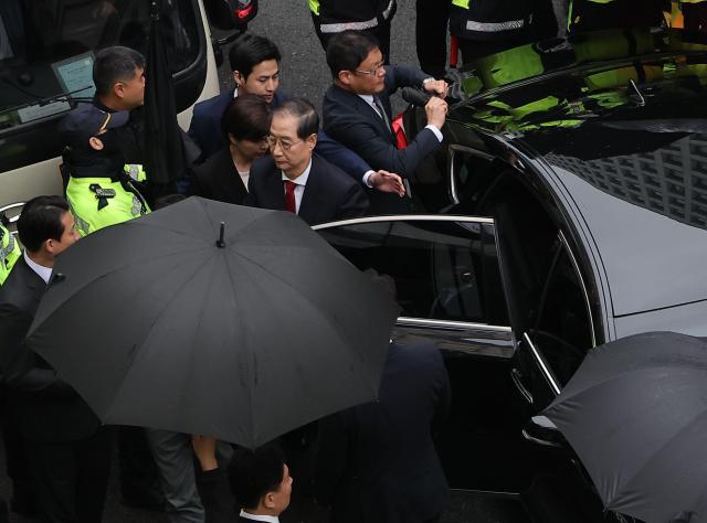 Former Prime Minister Han Duck-soo moves towards the PPP headquarters under escort May 10 2025 Yonhap
