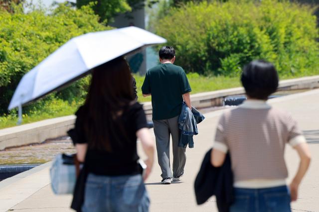 낮 동안 초여름 날씨를 보인 8일 서울 영등포구 여의도한강공원을 찾은 시민들이 겉옷을 손에 들고 산책하고 있다 202558
사진연합뉴스