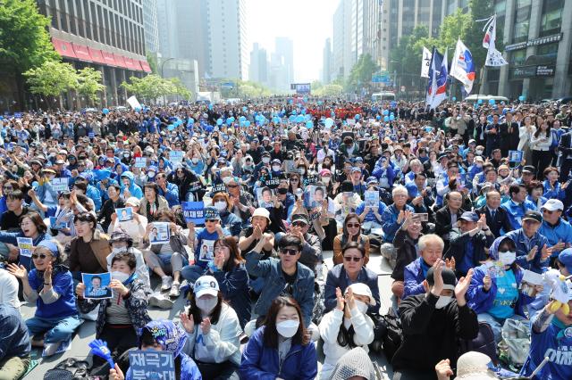 Supporters of Democratic Party of Koreas presidential candidate Lee Jae-myung cheer while listening to Lees campaign speech at Cheonggye Plaza in Gwanghwamun Seoul May 12 2025 Joint Press Corps