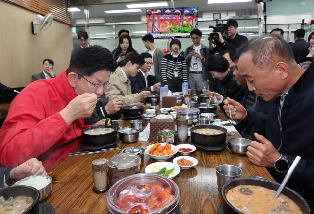 People Power Partys presidential candidate Kim Moon-soo eats sundae gukbap Korean sausage soup with vendors during a visit to Garak Market Songpa-gu Seoul his first official campaign event May 12 2025 Joint Press Corps