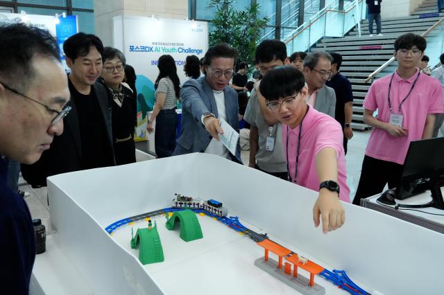 2024 전국 청소년 AI 창의 경진대회에 참여했던 학생들이 관람객과 심사위원들에게 출품한 시스템을 설명하고 있다사진포스코DX