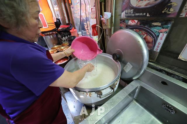 A restaurant merchant cooks rice at the Hairtail alley in Namdaemun market Seoul on May 12 2025 AJP Han Jun-gu
