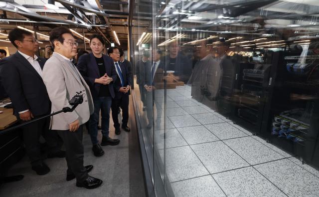 DP presidential candidate Lee Jae-myung second to left listens to explanations on data centers from Furiosa AI CEO Paik June at Furiosa AI headquarters in Gangnam April 14 2025 Jointed Press Corps