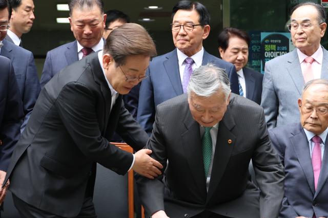 이재명 더불어민주당 대선 후보가 19일 서울 용산구 대한노인회관을 방문 기념촬영 자리에 앉는 이중근 회장을 부축하고 있다 사진연합뉴스