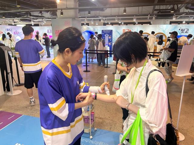 A customer tests out a product at the bclinicx booth AJP Candice Kim