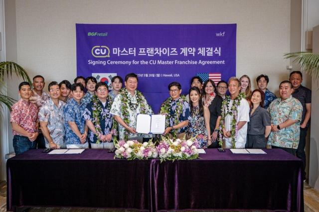 민승배 BGF리테일 대표가운데 왼쪽와 CU Hawaii Kurisu로버트 쿠리수 가운데 오른쪽 대표가 CU 하와이 진출 마스터 프랜차이즈 계약을 체결하고 양사 관계자들과 함께 기념 촬영을 하고 있다 사진BGF리테일