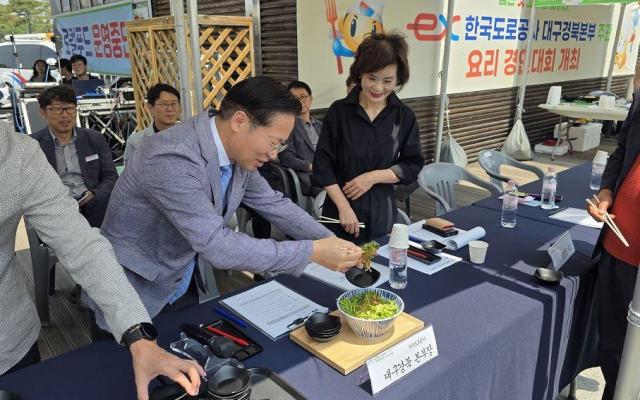 유호식 한국도로공사 대구경북본부장이 논공대구방향휴게소에서 열린 ‘대구경북 제일 맛 숨은 맛 고수 찾기’ 요리경연대회에서 참가자가 제출한 요리를 시식하고 있다 사진한국도로공사 대구경북본부