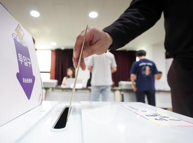A voter casts a ballot at an early voting station in Seoul on May 29 2025 Yonhap