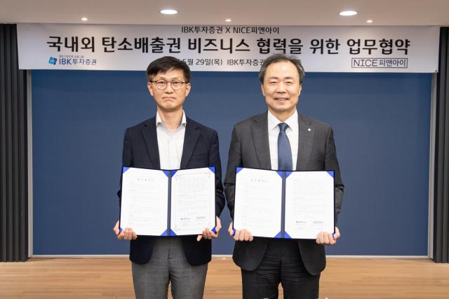 왼쪽부터 이태희 NICE피앤아이 정보사업본부장·박태동 IBK투자증권 세일즈앤트레이딩ST부문장이 지난 29일 서울 여의도 IBK투자증권 본사에서 탄소배출권 시장 활성화 및 평가기준 마련을 위한 전략적 업무협약 체결한 뒤 기념촬영 하고 있다 사진IBK투자증권