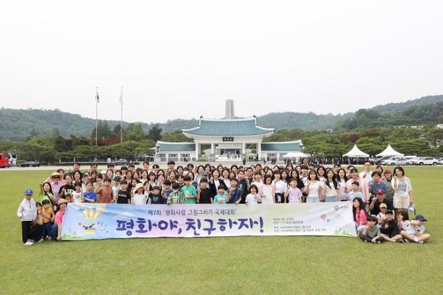제7회 평화사랑 그림그리기 국제대회 예선 참가자들이 국립서울현충원 현충문 앞 잔디광장에서 기념 촬영을 하고 있다 사진세계여성평화그룹IWPG 제공