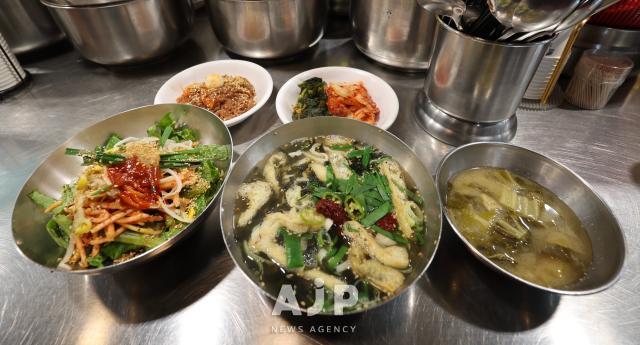 A set of bowls filled with various dishes is served on a table in this photo taken at a restaurant in Seoul on date Clockwise from left naengmyeon or cold noodles kimchi or picked cabbage dish doenjang jjigae or soy-bean paste soup kalguksu or noodle soup and barley rice