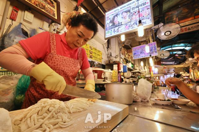 A vendor cuts noodles by hand at Kalguksu Alley in Namdaemun Market Seoul May 27 2025 AJP Han Jun-gu