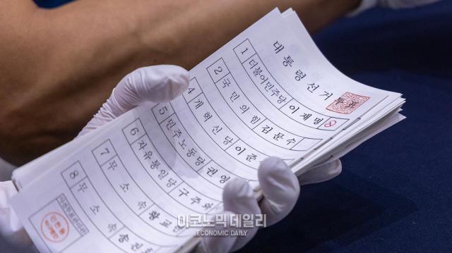 제21대 대선 개표소에서 개표사무원이 분류기를 통해 분류된 투표용지를 정리하고 있다 사진박명섭 기자