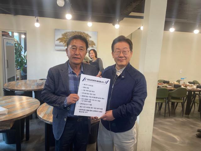 김세훈 더불어민주당 강원도당 부위원장이 지난 5월 2일 이재명 당시 대통령 후보와 화천군 발전을 위한 9대 제안 현황판을 들고 기념촬영을 하고 있다사진조재규 화천군의원