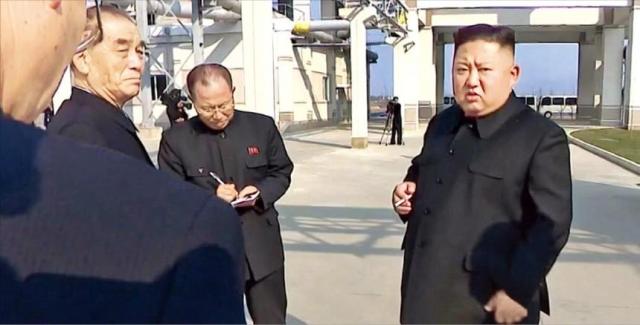 김정은 북한 국무위원장오른쪽이 2020년 5월 1일 순천 인비료공장 준공식에 참석해 오른손에 담배를 든 채 박봉주 국무위 부위원장왼쪽부터과 박태성 최고인민회의 의장에게 이야기하고 있다 사진조선중양TV·연합뉴스