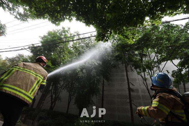 A firefighter extinguishes a fire with a hose at the Korean Buddhist history and culture memorial hall at Jogyesa temple in Jongno Seoul on June 10 2025 AJP Han Jun-gu