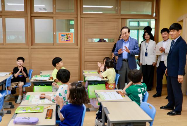 서거석 전북특별자치도교육감뒷줄 서 있는 사람 중 맨 왼쪽이 늘봄학교인 군산금빛초등학교를 찾아 학생들과 이야기를 나누고 있다사진전북특별자치도교육청