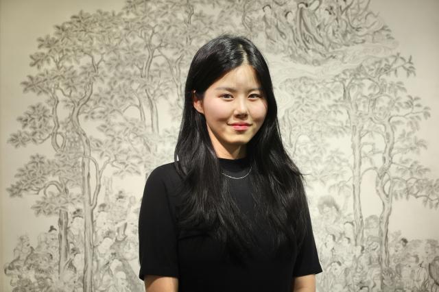 Artist Jeong Ha-yul poses for a photograph in front of her Buddhist painting Parinirvana displayed at Moowoosoo Gallery in Seoul on June 17 AJP Han Jun-gu