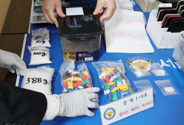 서울 동대문경찰서에서 경찰이 보이스피싱 조직으로부터 압수한 마약과 대포폰 등을 정리하고 있는 모습 사진연합뉴스