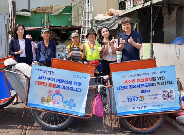 지난 19일 우리은행 서민금융진흥원 협동조합 끌림이 함께 폐지수거 어르신들에게 경량 리어카와 안전용품을 제공했다 우리은행 하현신 상생금융부장좌측과 서민금융진흥원 신승주 홍보협력실장우측이 전달식 이후 어르신들과 함께 기념사진을 촬영하고 있다 사진우리은행