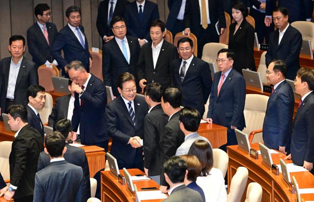 이재명 대통령이 26일 국회 본회의장에서 추가경정예산 시정연설을 마친 뒤 국민의힘 의원들과 악수하고 있다