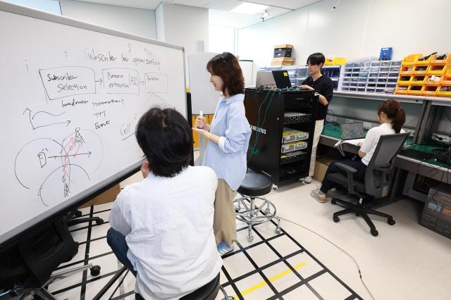 KT-삼성리서치 공동 연구팀이 무선망 최적화 기술 개발을 논의하는 모습