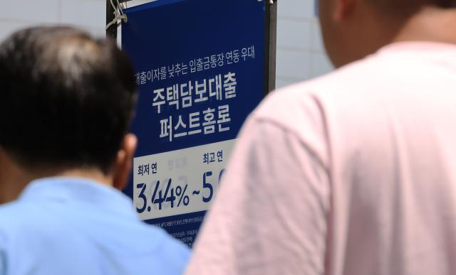 금리 하락 속에 새 정부 출범에 따른 주택·주식 등 자산가격 상승 기대까지 겹쳐 영끌영혼까지 끌어모아 대출 열기가 좀처럼 식지 않고 있다 15일 금융권에 따르면 5대 은행KB국민·신한·하나·우리·NH농협의 지난 12일 기준 가계대출 잔액은 750조792억원으로 5월 말748조812억원보다 1조9천980억원 불었다 사진은 15일 서울 시내 은행 앞 대출 홍보물을 지나는 시민 2025615 사진연합뉴스