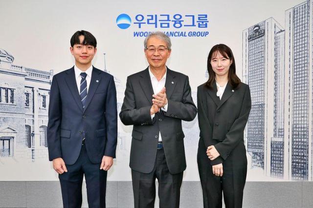 임종룡 우리금융 회장가운데이 그룹의 새 가족이 된 동양생명·ABL생명 직원에게 디지털 선도의 의미가 담긴 새로운 그룹 보조휘장을 달아주고 기념촬영을 하고 있다 사진우리금융그룹