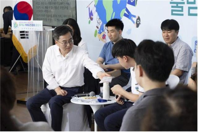 김동연 도지사가 지난달 30일 시흥에코센터에서 진행된 경기도 기후도민총회 출범식에서 땀 흘리는 학생 참가자에게 손수건을 건네고 있다 사진경기도