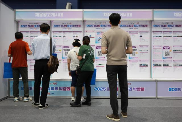 上月11日,在京畿道河南市综合运动场举行的“2025河南市工作岗位博览会”上求职者们正在查看招聘公告。【图片来源 韩联社】