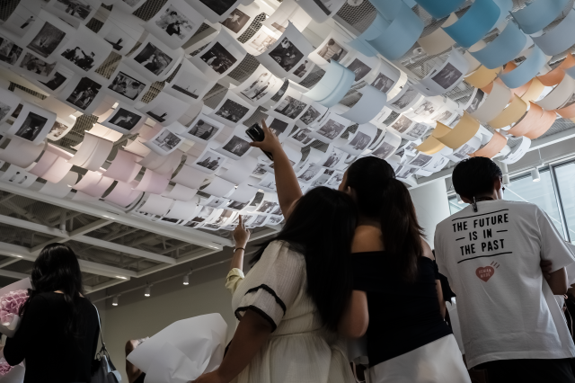 드라마 스틸컷을 활용한 행잉 전시를 관람하는 관람객들 사진한국관광공사