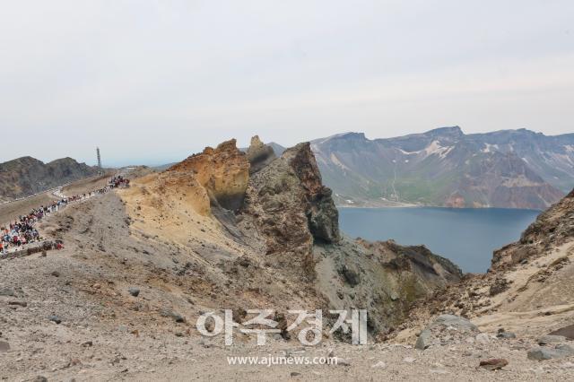 6월 27일 백두산 정상북파에 위치한 크기를 가늠하기 어려운 기암괴석 옆으로 사람들이 걸어다닌다 AJP 한준구 사진기자