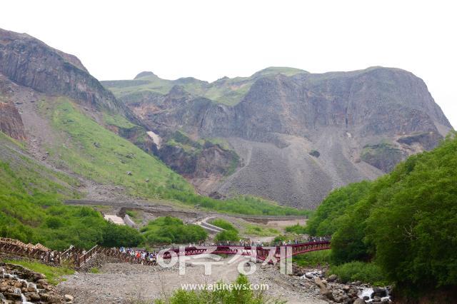 6월 27일 백두산의 장백폭포로 가는 등산로 뒤로 보이는 거대한 돌산 AJP 사진기자 한준구