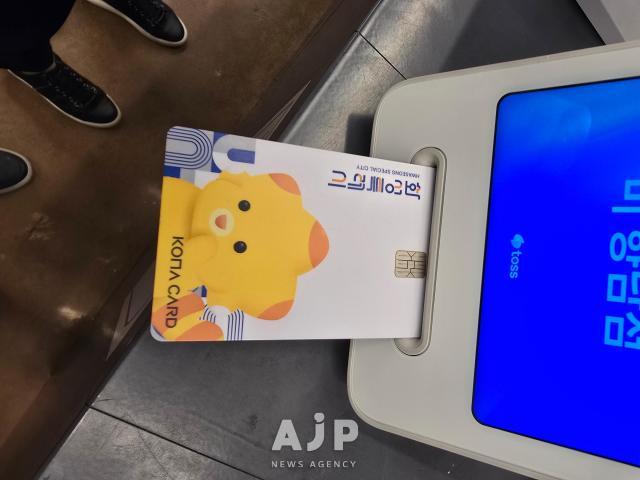Social worker Kim Eun-hee slides her local voucher card into the card reader to pay for her meals July 3 2025 AJP Kim Dong-young