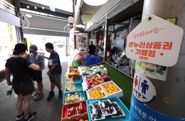A bright orange sign certifying a stalls acceptance of government issued vouchers at a traditional market in Seoul July 6 2025 Yonhap