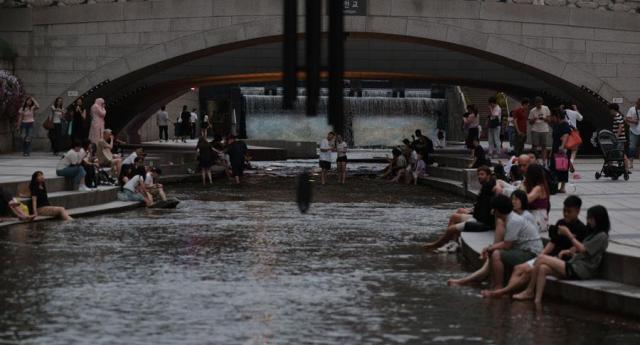 People cool themselves off at Cheonggye Stream in downtown Seoul on July 6 2025 Yonhap