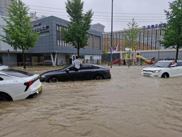 광주광역시 보건소 근처 도로가 물에 잠겨 운전자가 창문 밖으로 상황을 살펴보고 있다 사진독자제공