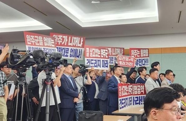 김관영 전북특별자치도지사 우범기 전주시장 정동영·이성윤 국회의원이 진행한 기자회견에 완주군의원과 주민들이 통합반대를 외치고 있다사진김한호 기자