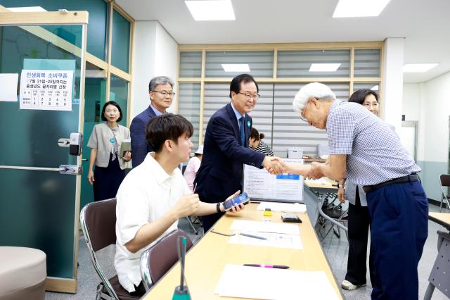 유희태 완주군수왼쪽 네 번째가 21일 용진읍을 찾아 민생회복 소비쿠폰을 신청한 군민들과 악수하고 있다사진완주군